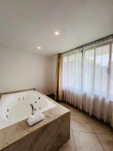 a bathroom with a bath tub and a large window at Hotel Las Puertas de Tepoztlan in Tepoztlán