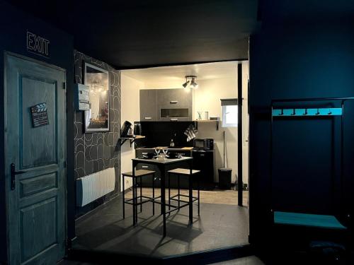 - une petite cuisine avec une table et deux tabourets de bar dans l'établissement CinéRoom Private Cinema in Bourges, à Bourges