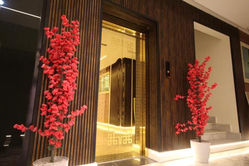 two red flowers in vases in front of a store at استديو انيق بـ دخـول ذكي in Riyadh