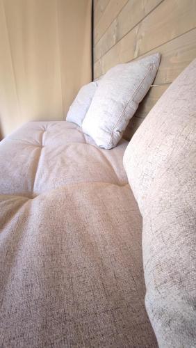 a bed with two pillows on top of it at Il Lago dei Cigni - Glamping & Restaurant in Corsalone
