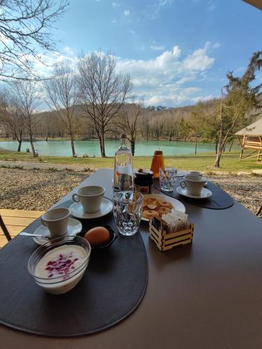 a table with a plate of food and a bottle of water at Il Lago dei Cigni - Glamping & Restaurant in Corsalone