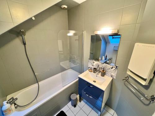 a bathroom with a tub and a sink and a shower at Charmant appart T2 tout équipé in Montbéliard
