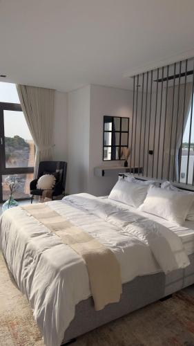 a large white bed in a bedroom with a window at Private Pool Villa Rawaq Chalet in Āsam