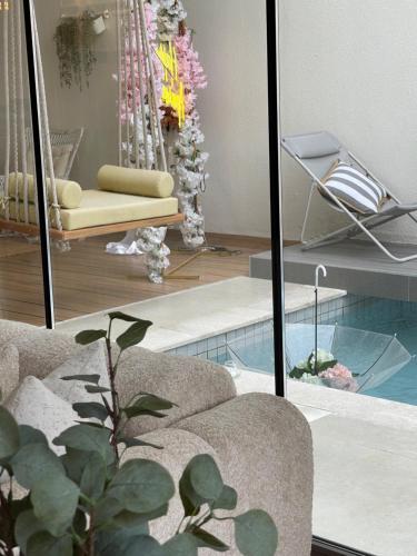 a living room with a couch and a mirror at Private Pool Villa Rawaq Chalet in Āsam
