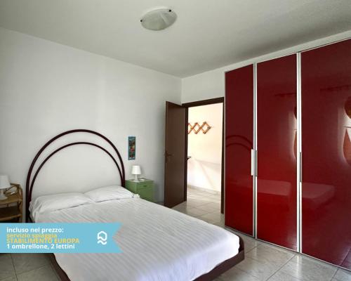 a bedroom with a white bed and a red closet at RS316 - Marcelli, bilocale in residence fronte mare pt in Marcelli