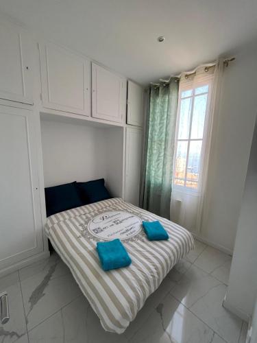 une chambre avec un lit avec deux oreillers bleus dessus dans l'établissement Seaview Apartment with 1 Bedroom - Next to Monaco, à Beausoleil