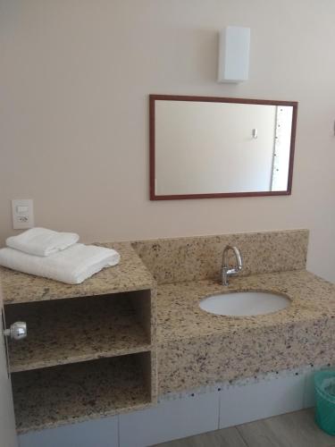a bathroom counter with a sink and a mirror at Leme Plaza Hotel in Leme