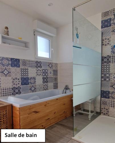 une salle de bain avec une baignoire et une fenêtre dans l'établissement Orée des bruyères, à Ecques