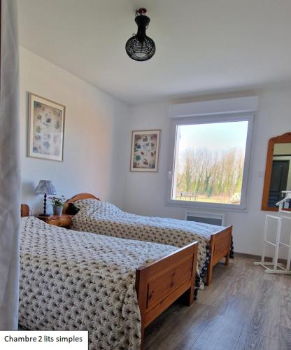 une chambre avec deux lits et une fenêtre dans l'établissement Orée des bruyères, à Ecques