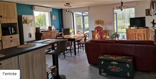 une cuisine et un salon avec un canapé et une table dans l'établissement Orée des bruyères, à Ecques