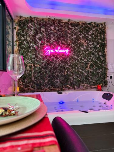 - une table avec une assiette et un verre de vin ainsi qu'une baignoire dans l'établissement Spa relaxing, à Nantes