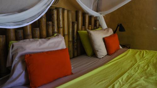 a bed with colorful pillows on top of it at YAY Sustainable in Guachaca