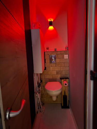 La salle de bains rouge est pourvue de toilettes et d'une lumière rouge. dans l'établissement Spa relaxing, à Nantes