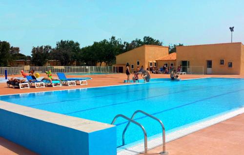 a large swimming pool with people sitting around it at Village vacances & camping de Gruissan in Gruissan