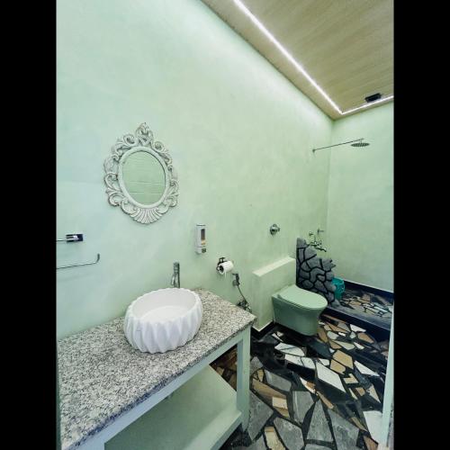 a bathroom with a sink and a toilet at Rajbongshi Heritage Inn in Dibrugarh