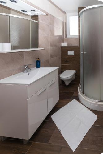 a bathroom with a sink and a shower and a toilet at Royal Resort Gajac in Novalja
