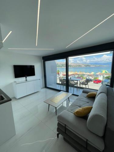 a living room with a couch and a view of the ocean at Villa San Sebastian-direct sea view in Baška