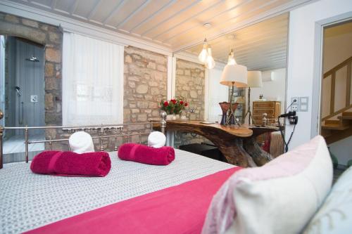 a bedroom with a bed with red pillows on it at Limnos Experience in Mirina