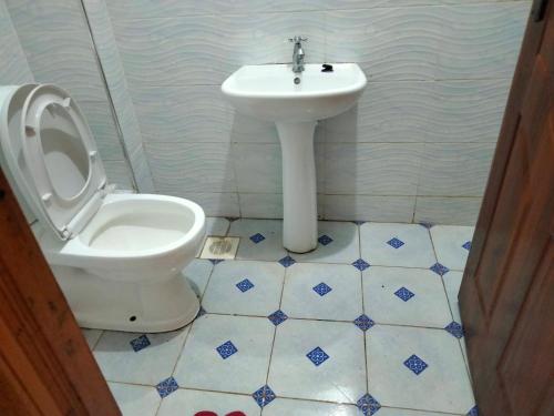 a bathroom with a toilet and a sink at Traveler's Staycation II in Rungiri