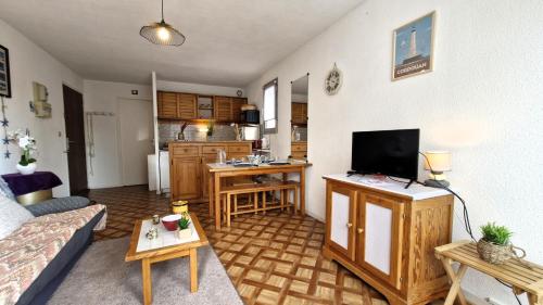 Il comprend un salon doté d'un canapé et d'une télévision. dans l'établissement Vaux sur Mer - APPARTEMENT résidence LES TROIS MOUSQUETAIRES - Plage de Nauzan, à Vaux-sur-Mer