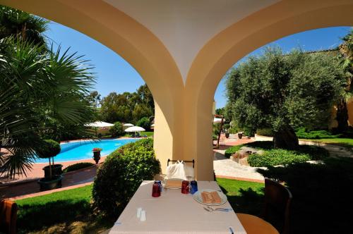 a table in an archway with a view of a pool at Hotel Arbatasar in Àrbatax