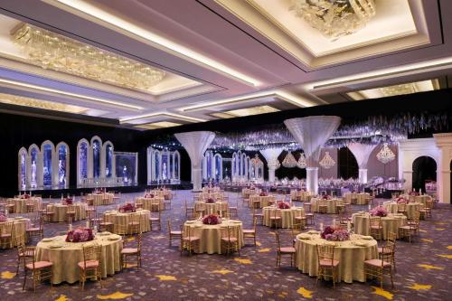 a banquet hall with tables and chairs and chandeliers at The Westin Surabaya in Surabaya