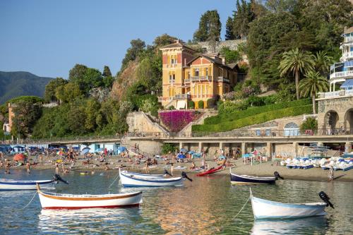 a group of people on a beach with boats in the water at La Casa del Sole in Carrodano Inferiore