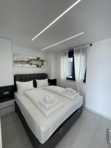 a bedroom with a large bed with two towels on it at Villa San Sebastian-direct sea view in Baška