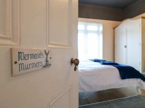 a bedroom with a bed and a sign on the door at Marine House in Pevensey