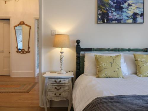 a bedroom with a bed and a lamp on a night stand at Marine House in Pevensey