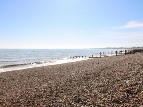 a beach with a pier and the ocean at Marine House in Pevensey