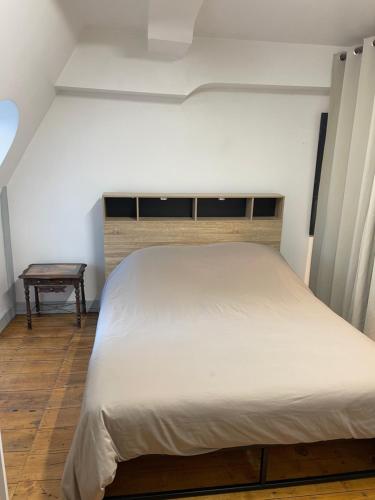 a bedroom with a large bed and a table at Château de Lagravade - Appartement 2 chambres - 3eme étage in Layrac