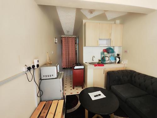 a living room with a couch and a table and a kitchen at Traveler's Staycation II in Rungiri