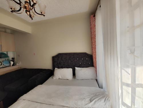 a small bedroom with a bed and a couch at Traveler's Staycation II in Rungiri