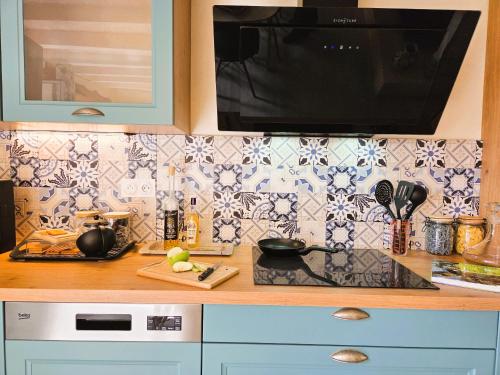 a kitchen with a counter with a sink and a microwave at Fleurs de vigne, gîte charentais au grand coeur in Bouteville