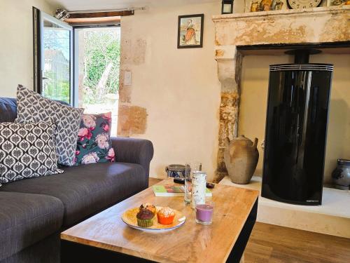 a living room with a couch and a coffee table at Fleurs de vigne, gîte charentais au grand coeur in Bouteville