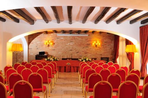 a conference room with red chairs and a table at Hotel Arbatasar in Àrbatax