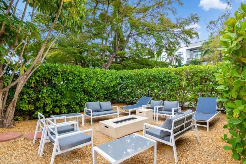 a group of blue chairs and a table and a hedge at Sandy Waves in Naples