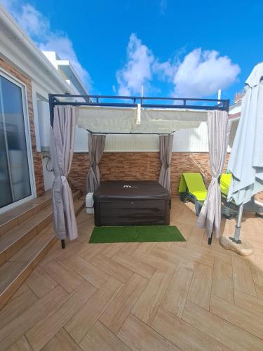 a bedroom with a bed with a canopy and a wooden floor at Zurrinha holidays whit jacuzzi in Quarteira