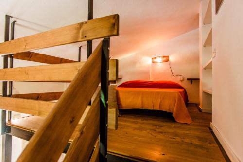 niewielka sypialnia z łóżkiem i schodami w obiekcie Agriturismo Serignano alle Rocchette w mieście Castiglione della Pescaia