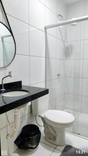 a bathroom with a toilet and a sink and a mirror at Dunas residence casa 03 in Santo Amaro