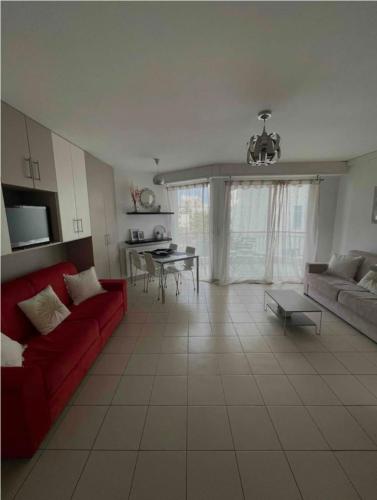 un salon avec un canapé rouge et une table dans l'établissement Bright apartment - sea view, à Antibes