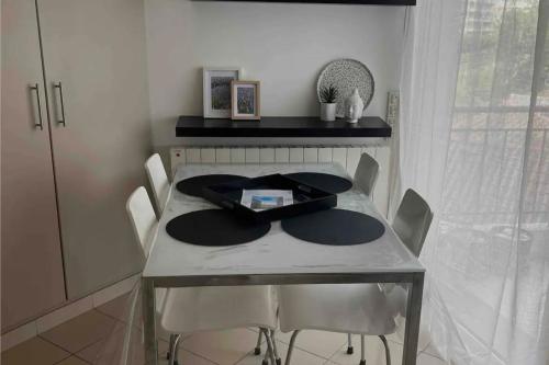 - une table à manger avec des chaises et une table dans l'établissement Bright apartment - sea view, à Antibes