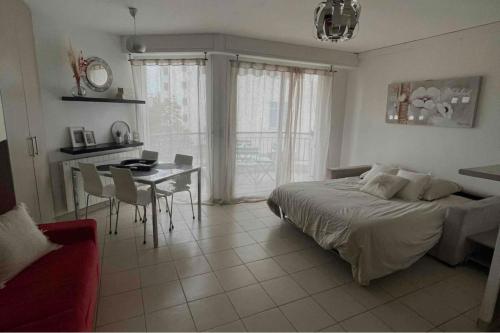 une chambre avec un lit, une table et des chaises dans l'établissement Bright apartment - sea view, à Antibes