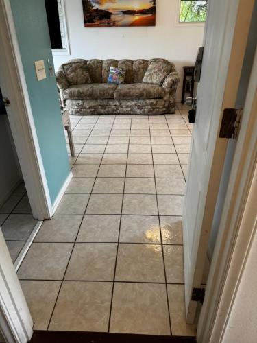 a living room with a couch and a tiled floor at Yonegan Maui Getaways - Haiku in Haiku