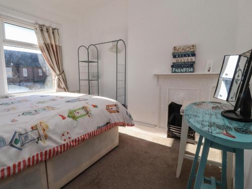 Un dormitorio con una cama y una mesa y una ventana. en 23 Dock Road, en Lytham St Annes