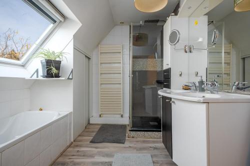 une salle de bain avec une baignoire, un lavabo et une douche dans l'établissement Cosy Family Home, à Wittenheim