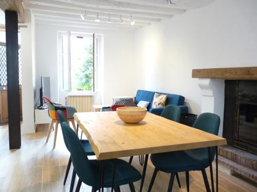 a living room with a wooden table and chairs at Le Passage du Roi, maison de ville, jardin et garage au coeur d'Amboise in Amboise