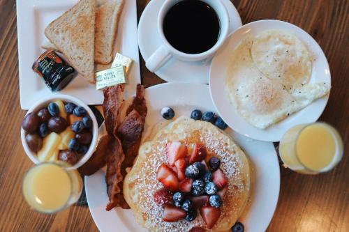 a plate of breakfast food with pancakes and bacon and a cup of coffee at Marriott Dallas Fort Worth Westlake in Westlake