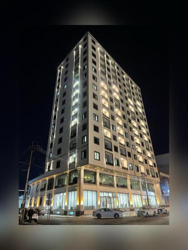 a tall building with cars parked in front of it at MyFlower 3 Hotel in Erbil
